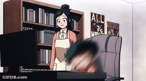 Woman In Apron Standing Next To Man In Chair In Library GIF