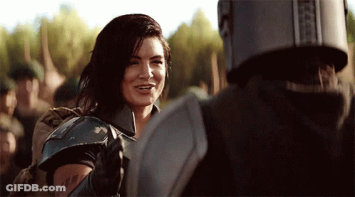 Woman In Armor Smiling At Man In Helmet GIF