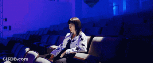 Woman In Auditorium With Purple Lights GIF