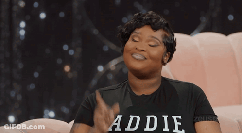 Woman In Baddie Shirt Sitting On Pink Couch GIF