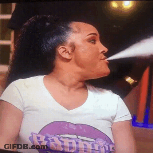 Woman In Baddie T-Shirt Blowing Smoke GIF