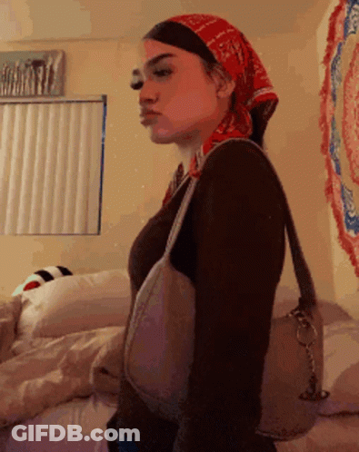 Woman In Bandana And Purse Standing In Bedroom GIF