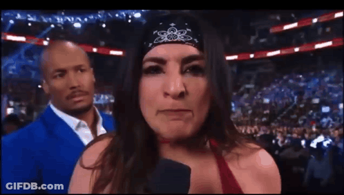 Woman In Bandana Talking Into Microphone With Man In Blue Suit GIF