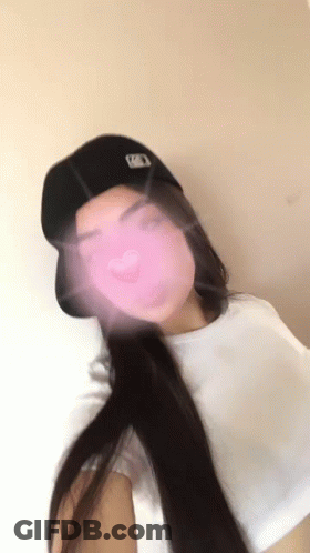 Woman In Baseball Cap Taking Selfie With Pink Heart GIF