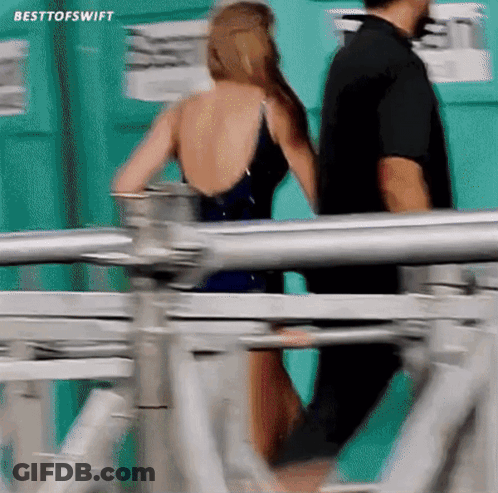 Woman In Bathing Suit Walking With Man Behind GIF