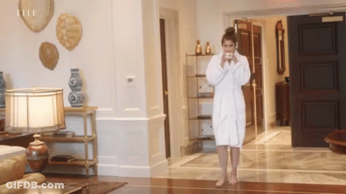 Woman In Bathrobe Drinking Coffee With Elle On Wall GIF