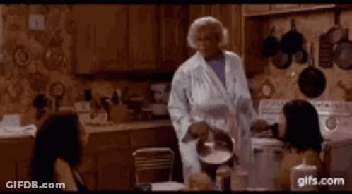 Woman In Bathrobe Holding Pot In Kitchen GIF