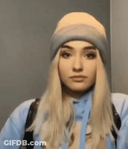 Woman In Beanie And Blue Hoodie Looking At Camera GIF