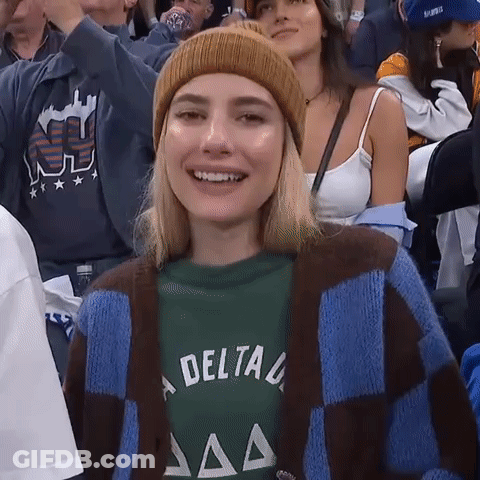 Woman In Beanie And Delta Shirt Smiling In Crowd GIF