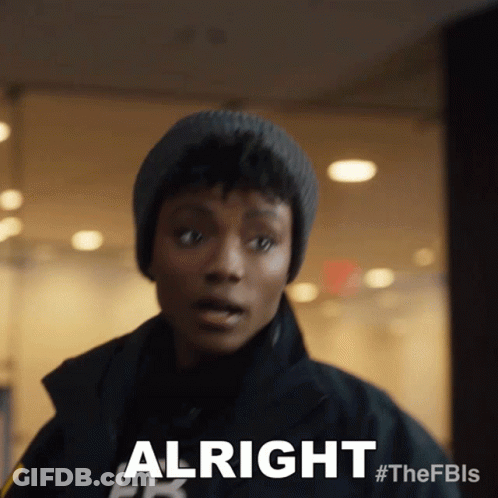 Woman In Beanie And Jacket Saying Alright GIF