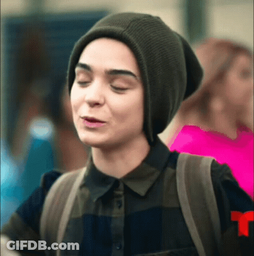 Woman In Beanie And Plaid Shirt Making Funny Face With Backpack GIF