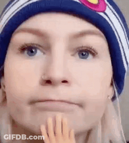Woman In Beanie Holding Chin GIF