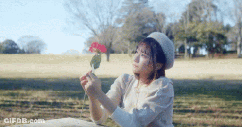 Woman In Beret Holding Red Flower GIF
