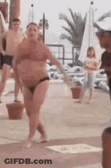 Woman In Bikini Dancing On Beach With Crowd GIF