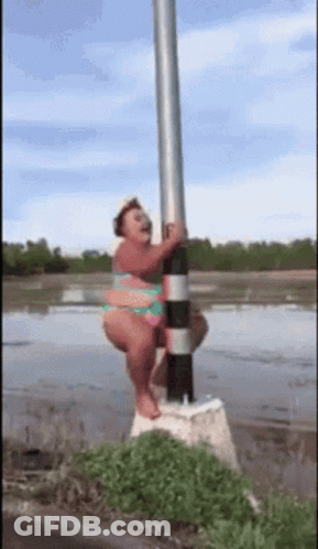Woman In Bikini Hanging From Pole In Water GIF