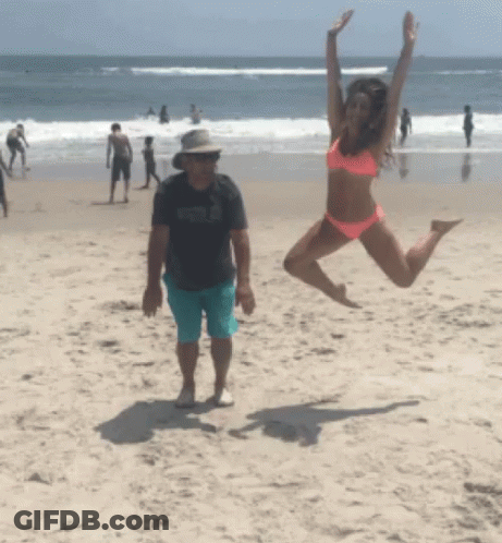 Woman In Bikini Jumping On Beach GIF