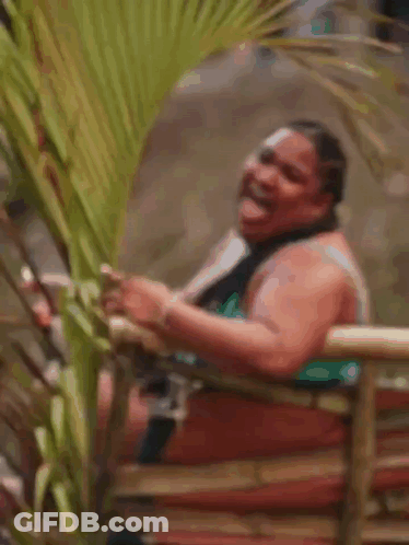 Woman In Bikini Laughing On Bamboo Fence GIF