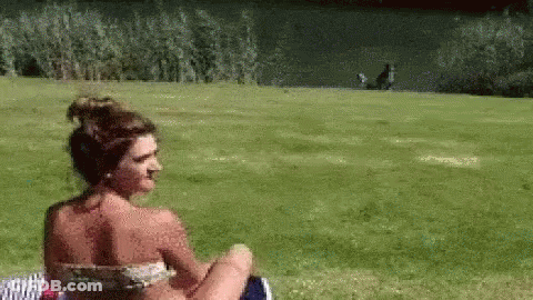 Woman In Bikini Sitting In Grass GIF