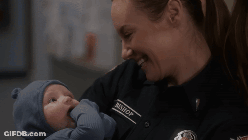Woman In Bishop Uniform Holding Baby GIF