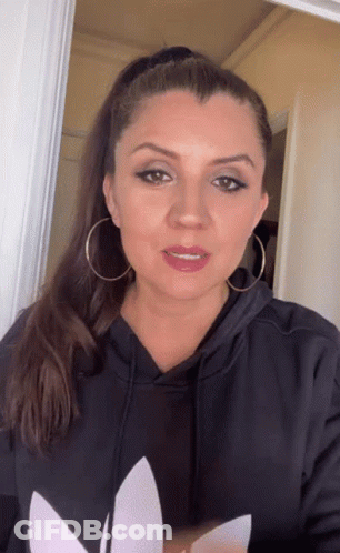 Woman In Black Adidas Hoodie And Earrings Looking At Camera GIF