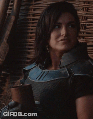Woman In Black And Blue Armor Smiling With Cup GIF