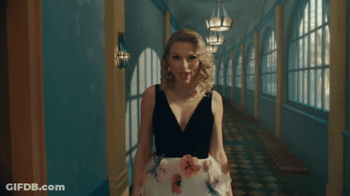 Woman In Black-And-White Dress Walking Hallway GIF