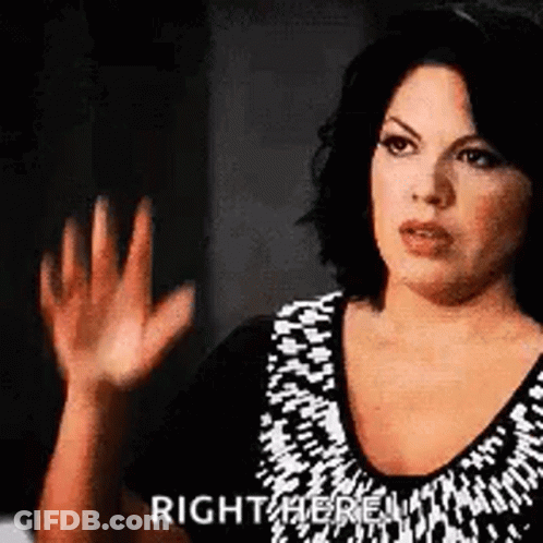 Woman In Black And White Dress Waving Right Here GIF