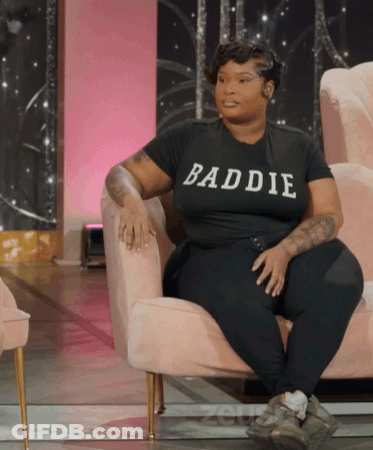 Woman In Black Baddie Shirt Sitting In Chair GIF