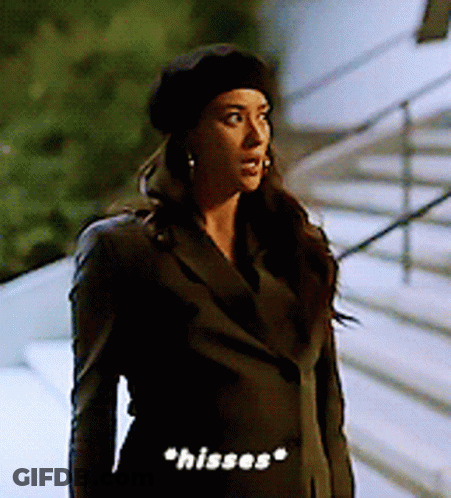 Woman In Black Beret And Jacket Saying Hisses GIF