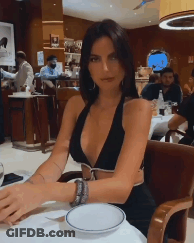 Woman In Black Bikini Top At Table GIF