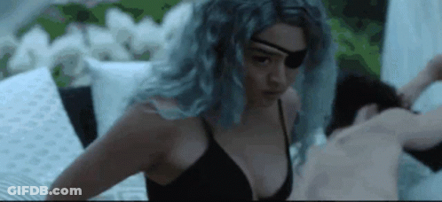 Woman In Black Bra And Eye Patch Laying On Bed Next To Man GIF