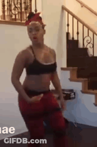 Woman In Black Bra And Red Pants Dancing Next To Stairs GIF