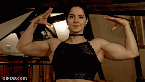 Woman In Black Bra Flexing Arms GIF