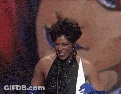 Woman In Black Dress And Blue Gloves Giving Speech On Stage GIF