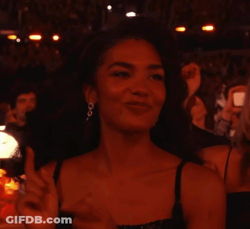 Woman In Black Dress And Earrings Smiling GIF