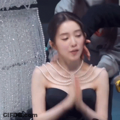 Woman In Black Dress And Pearl Necklace Praying GIF