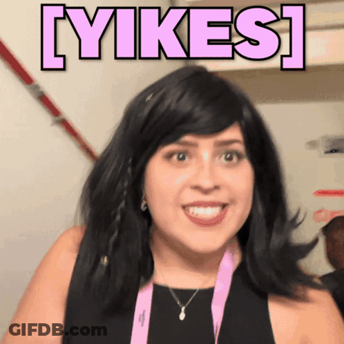 Woman In Black Dress And Pink Lanyard Smiling Beside Yikes Sign GIF