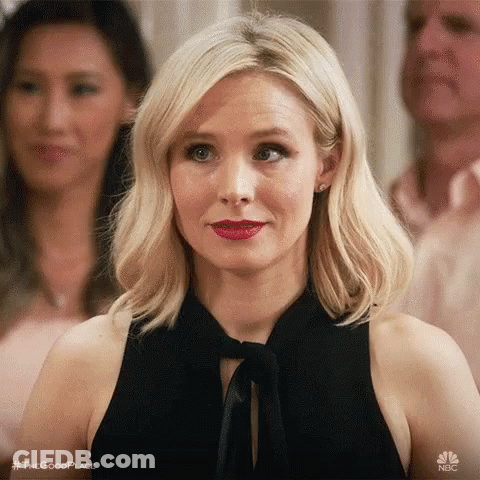 Woman In Black Dress And Red Lipstick Looking At Camera GIF