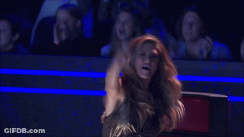 Woman In Black Dress Arms Outstretched To Crowd GIF