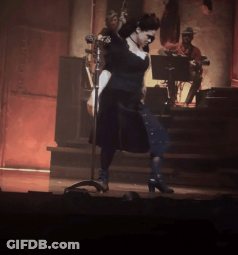 Woman In Black Dress At Microphone GIF