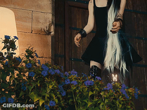 Woman In Black Dress By Wooden Door GIF