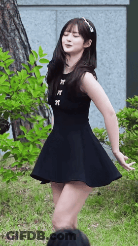 Woman In Black Dress Dancing In Grass GIF