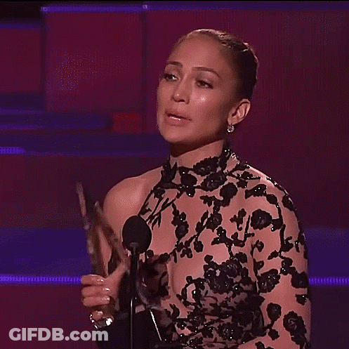 Woman In Black Dress Flexing At Microphone GIF