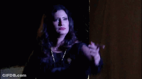 Woman In Black Dress Hand Up In Dark GIF