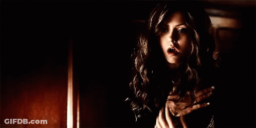 Woman In Black Dress Holding Hands To Chest GIF