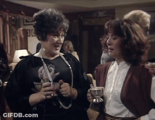 Woman In Black Dress Holding Silver Cup GIF
