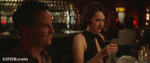Woman In Black Dress Holding Wine Glass Next To Man GIF