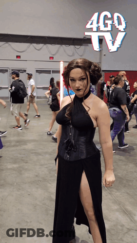 Woman In Black Dress In Front Of Ago TV Sign GIF