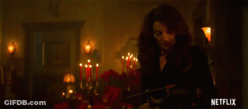 Woman In Black Dress In Room With Candles GIF