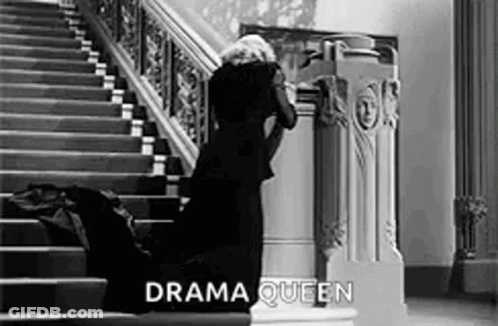 Woman In Black Dress Kneeling On Stairs Black And White GIF